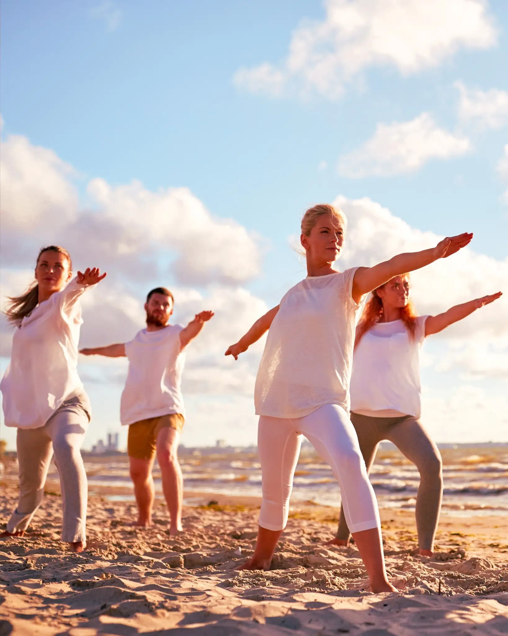 Eine Gruppe von Menschen, die am Strand Yoga macht